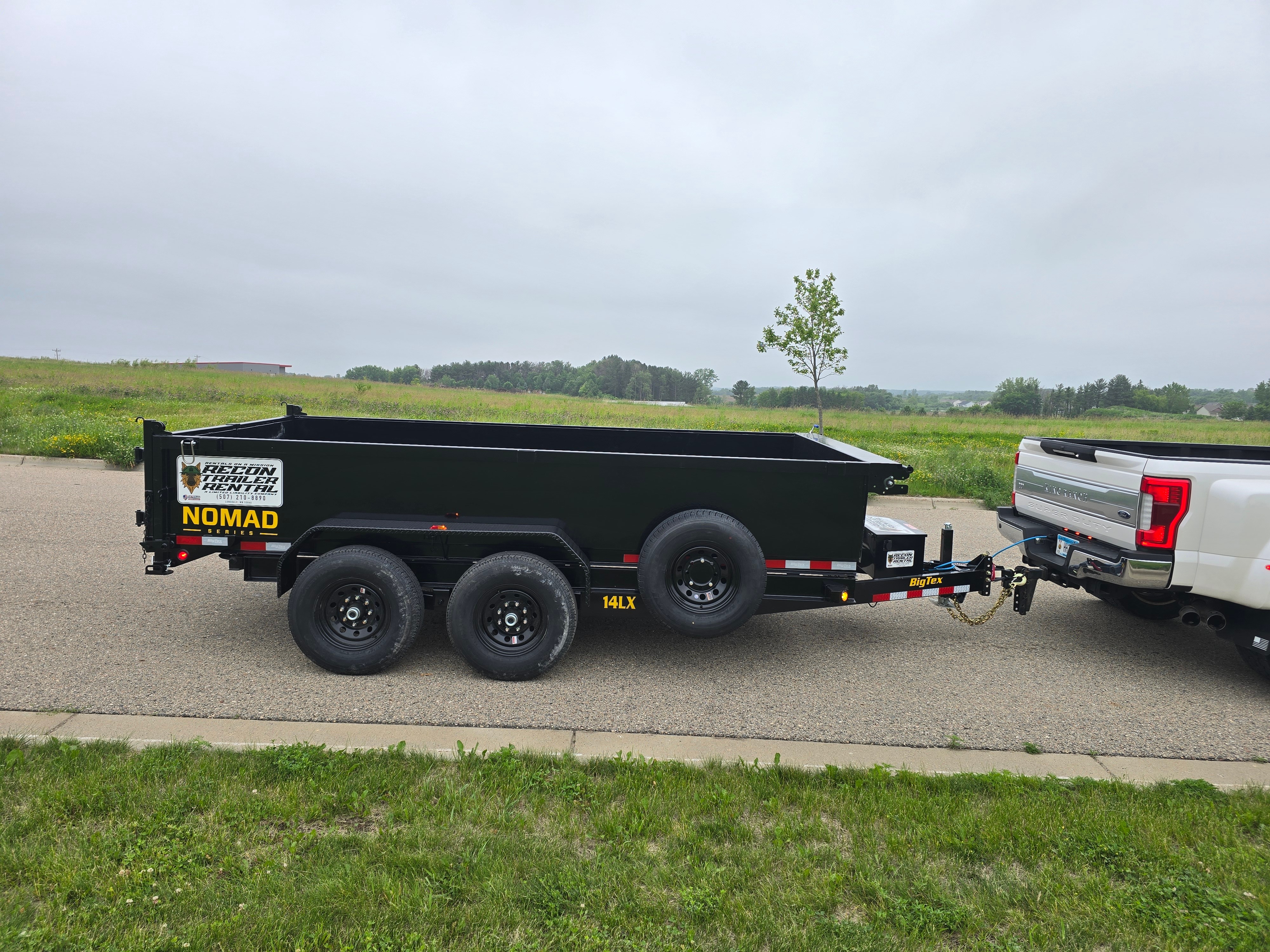 BigTex 14K dump trailer detail showing NOMAD branding and heavy-duty construction