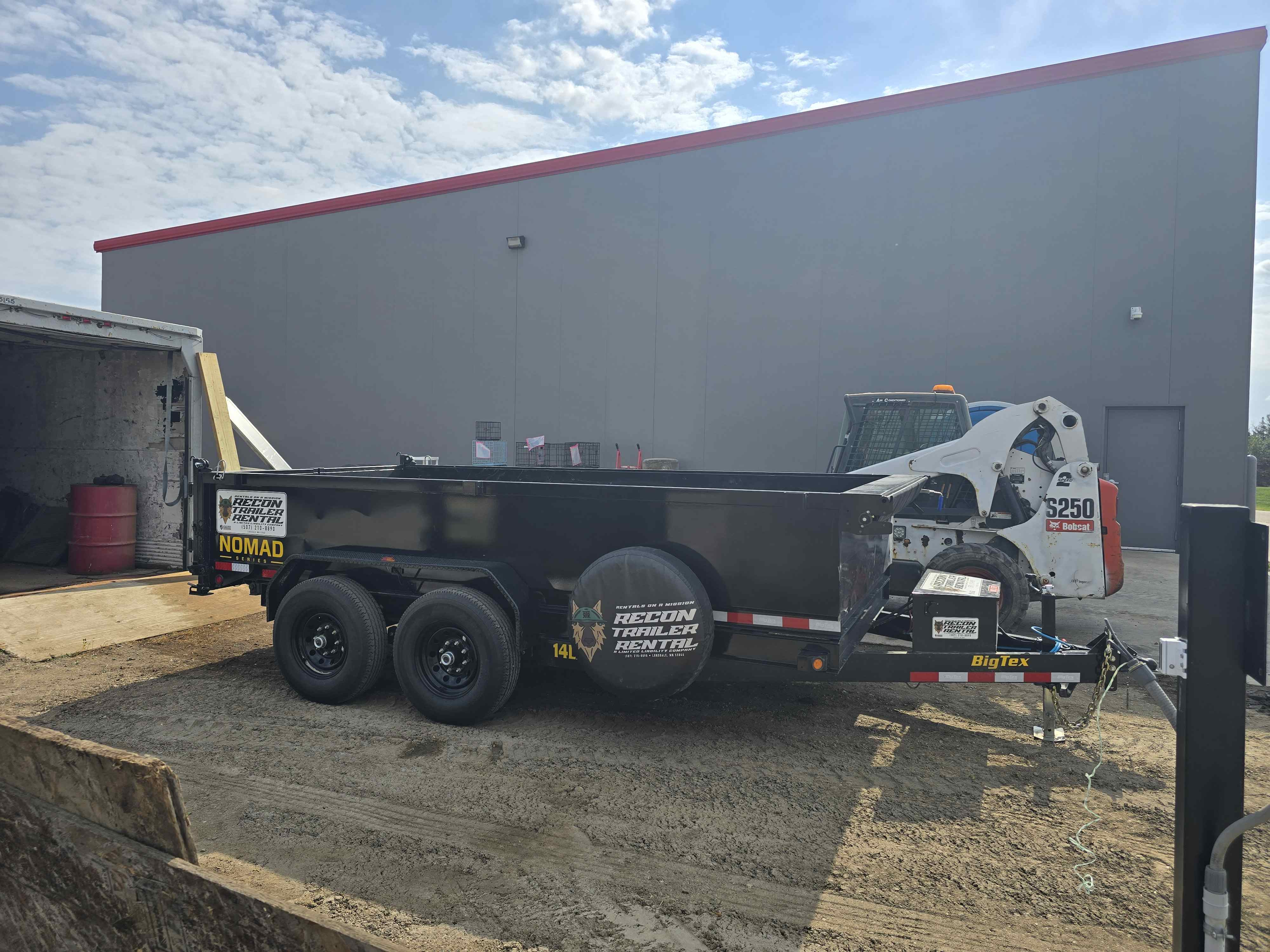 BigTex dump trailer loaded with a Bobcat S250 skid steer for hauling equipment