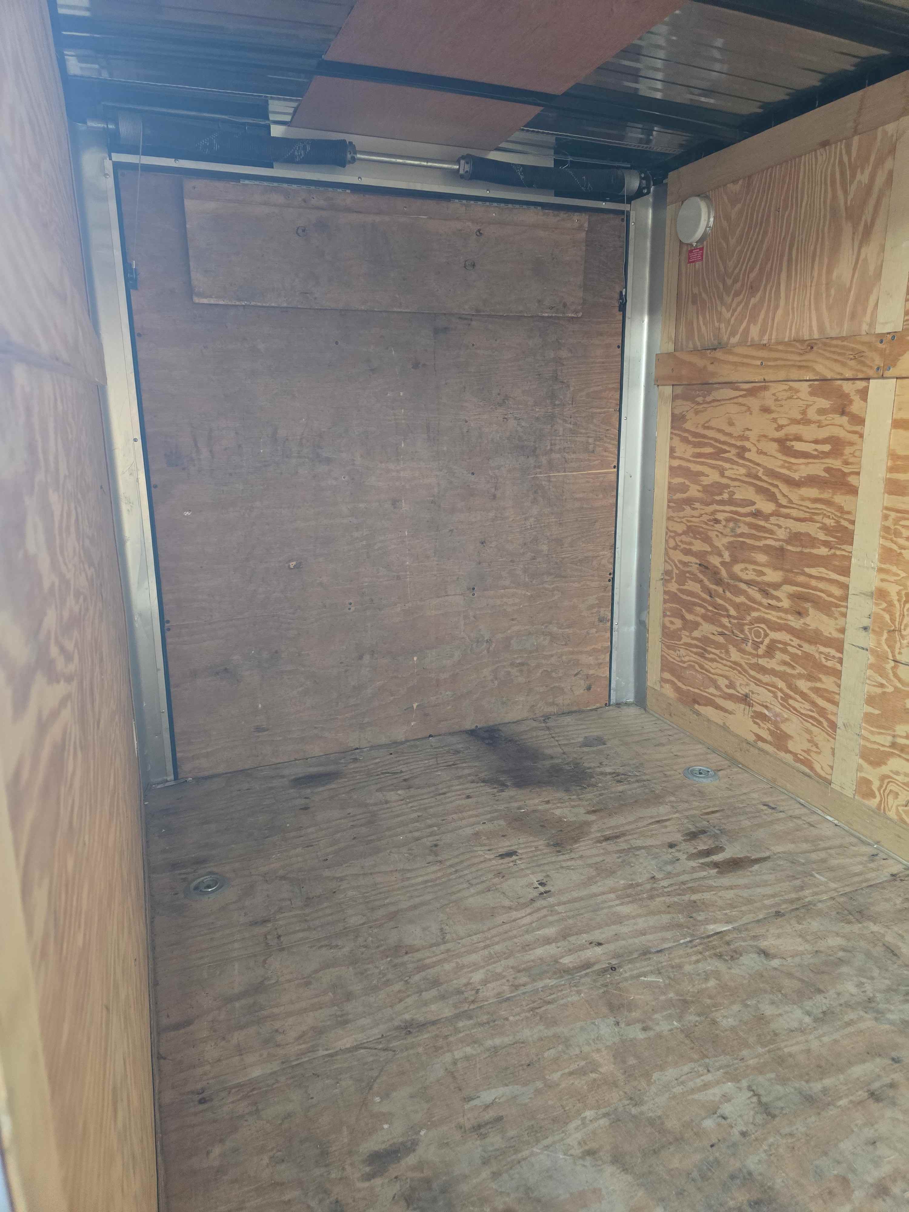 Wood-lined interior of the 6x12 enclosed cargo trailer with rear door hardware