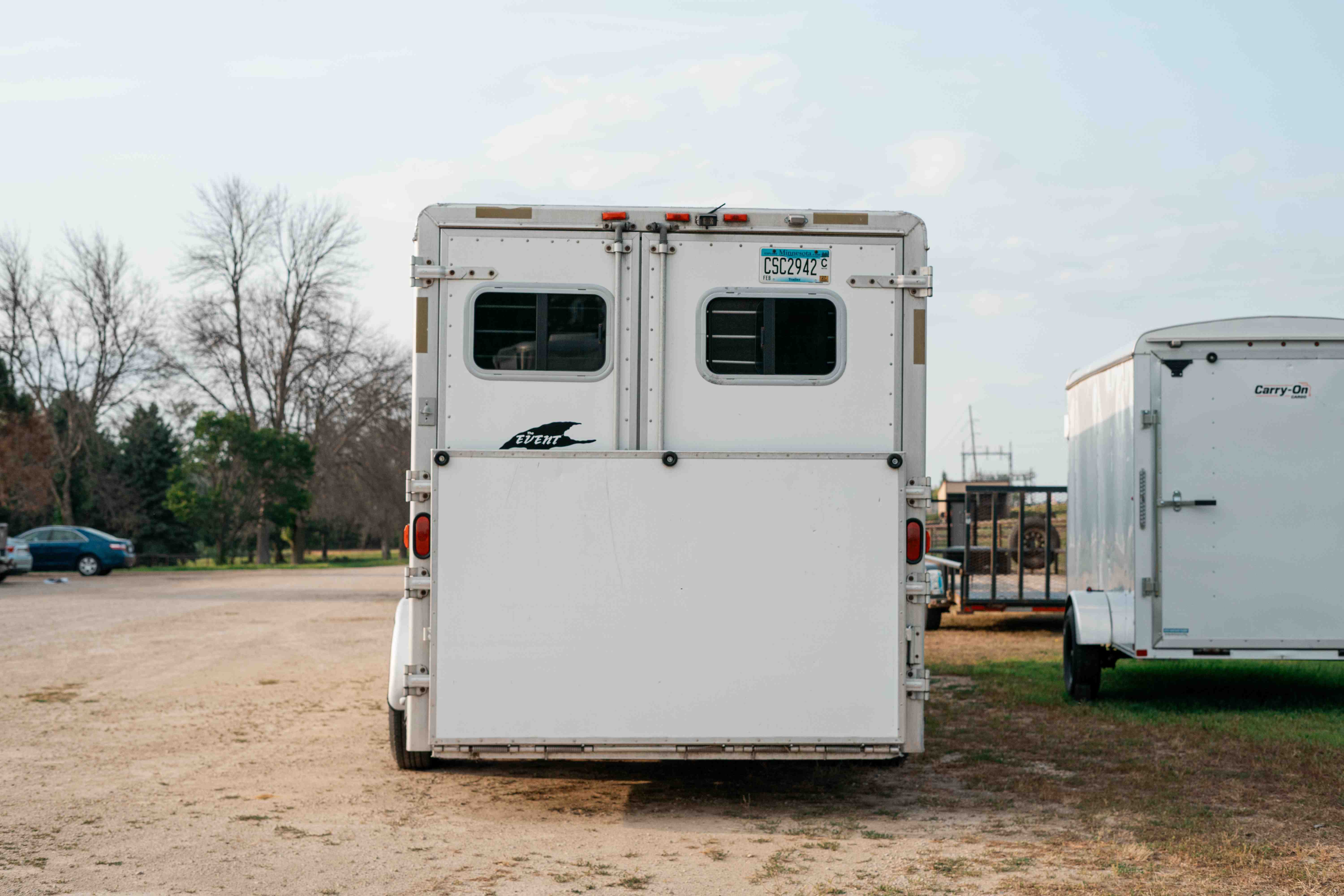 Exiss SS600 horse trailer rear view parked near another cargo trailer