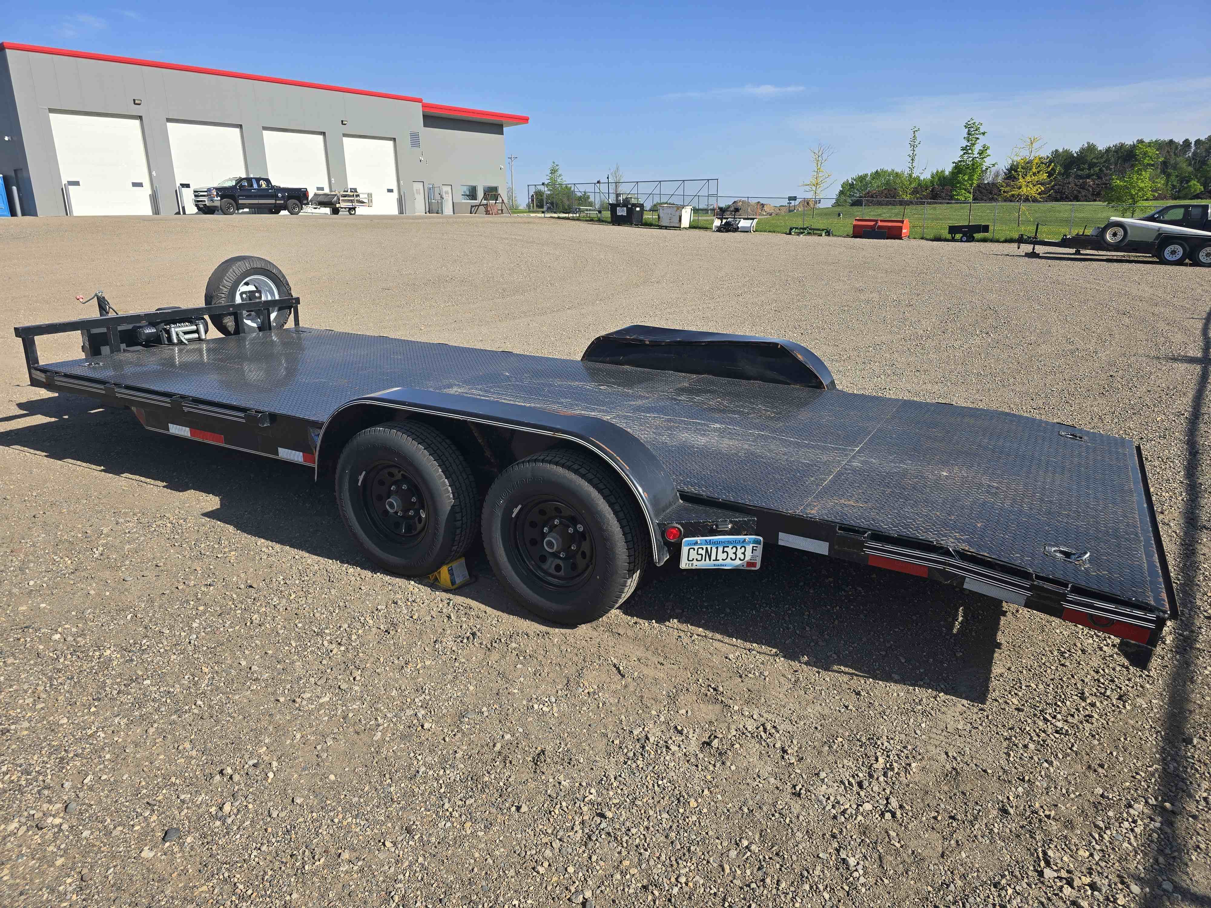 East Texas 12K car trailer angle view showing dual axles and tie-down points